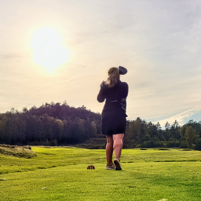 Women taking tee shot in sunlight - Ultimate guide to Golf sunglasses